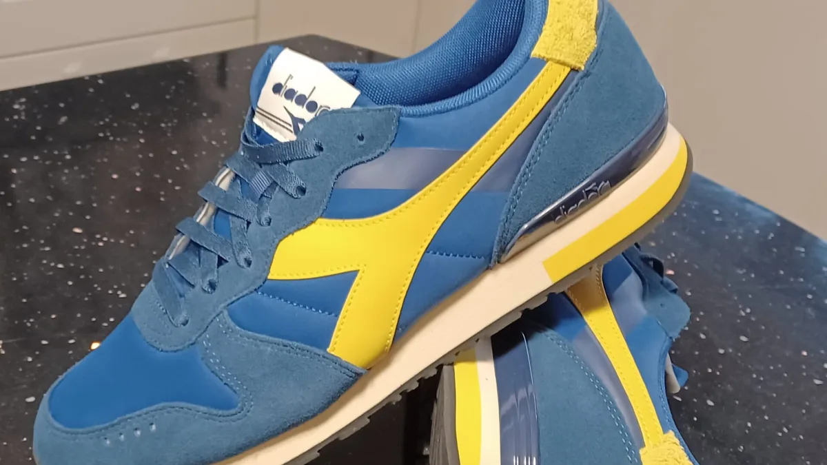 Кроссовки Diadora из синей замши крупным планом: ворсистая поверхность, гладкие накладки и жёлтые полосы