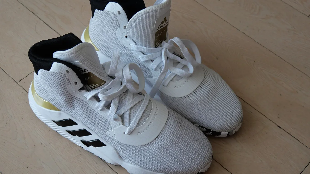 Белые баскетбольные кроссовки Adidas с высоким воротником и сетчатым верхом на деревянном полу
